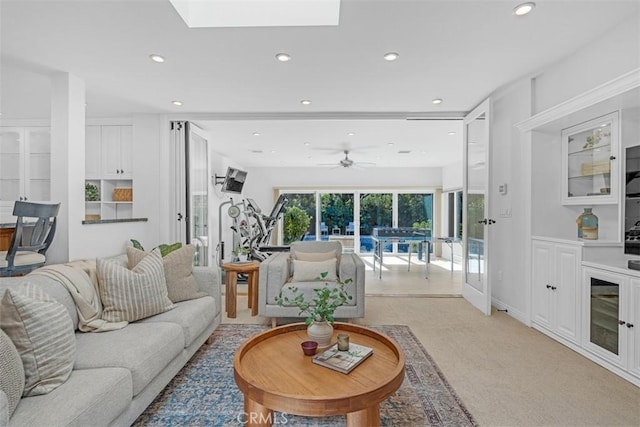 carpeted living room featuring a skylight