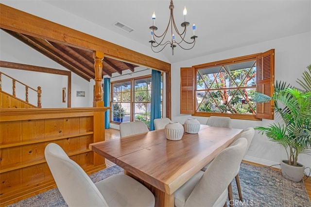 dining space featuring a chandelier, light hardwood / wood-style floors, and vaulted ceiling with beams