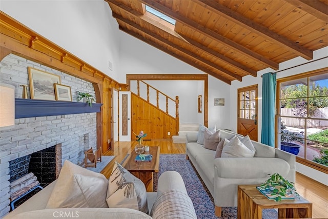 living room featuring wood-type flooring, a brick fireplace, wooden ceiling, and beam ceiling