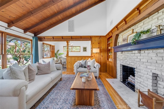 living room with wood-type flooring, high vaulted ceiling, a brick fireplace, wooden ceiling, and beam ceiling