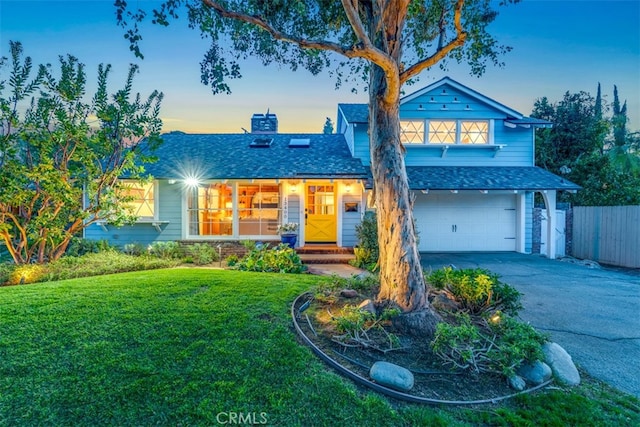 view of front of property with a garage and a lawn