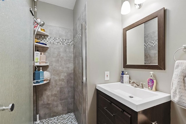 bathroom featuring a shower with door and vanity