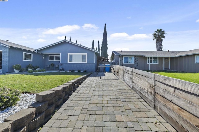 single story home featuring a front lawn