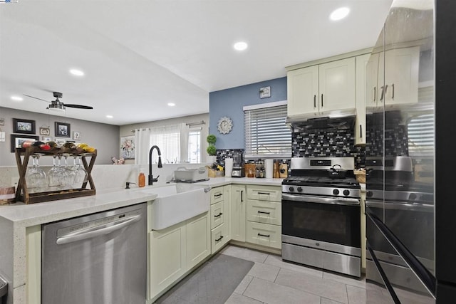 kitchen with appliances with stainless steel finishes, ventilation hood, sink, light tile patterned floors, and kitchen peninsula