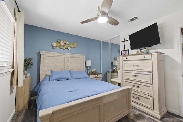 bedroom with ceiling fan, dark hardwood / wood-style flooring, and a closet