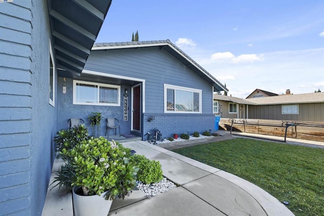 entrance to property with a lawn