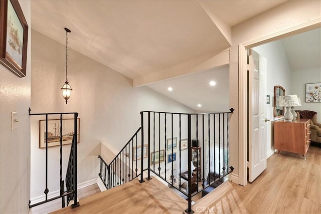 hall with vaulted ceiling and light hardwood / wood-style floors