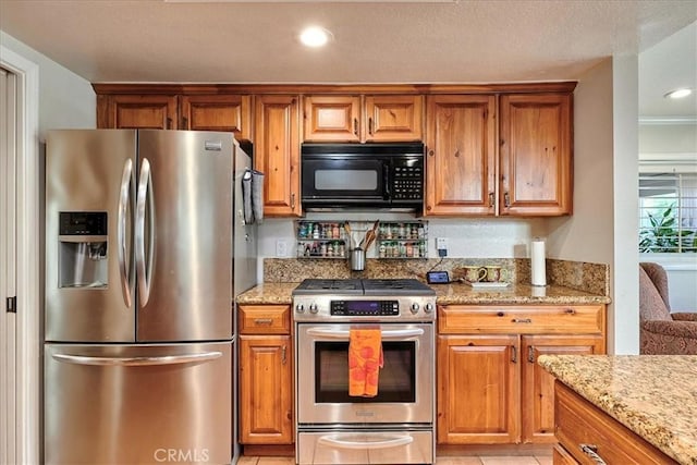 kitchen with light stone countertops and appliances with stainless steel finishes