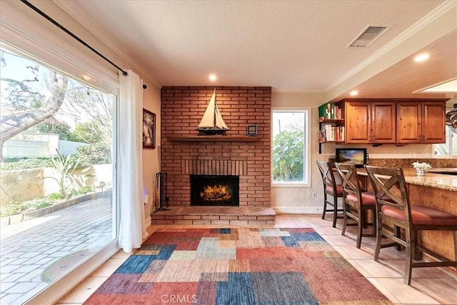 interior space with ornamental molding and a brick fireplace