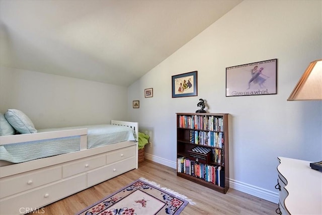 bedroom with light hardwood / wood-style floors and vaulted ceiling