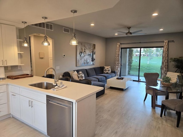 kitchen featuring decorative light fixtures, dishwasher, sink, and white cabinets