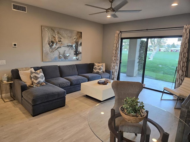 living room with ceiling fan and light hardwood / wood-style flooring