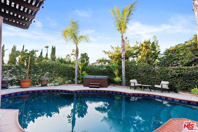 view of pool with a hot tub