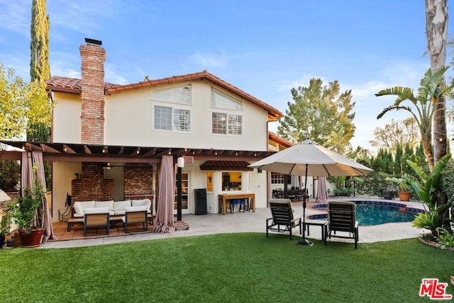 back of house with a patio, an outdoor hangout area, an outdoor bar, and a lawn