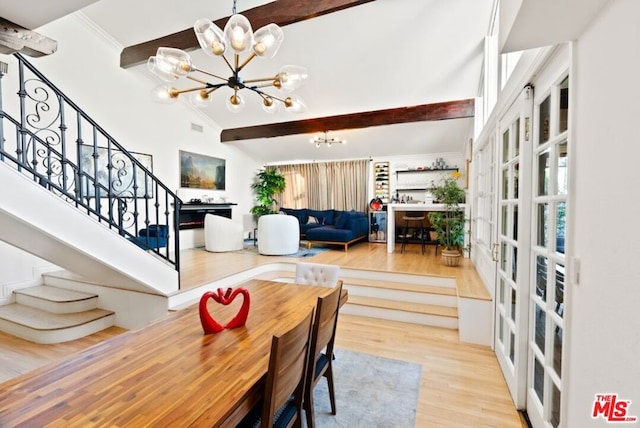 dining space with a chandelier, a high ceiling, ornamental molding, hardwood / wood-style flooring, and beam ceiling