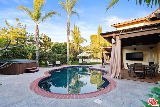 view of swimming pool with a hot tub and a patio area