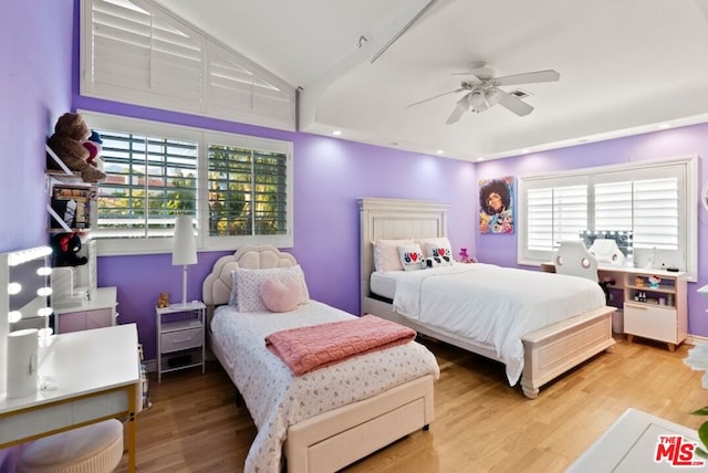 bedroom featuring multiple windows, hardwood / wood-style flooring, lofted ceiling, and ceiling fan