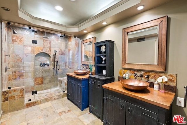 bathroom featuring vanity, backsplash, an enclosed shower, and crown molding