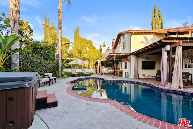 view of swimming pool with a hot tub and a patio area