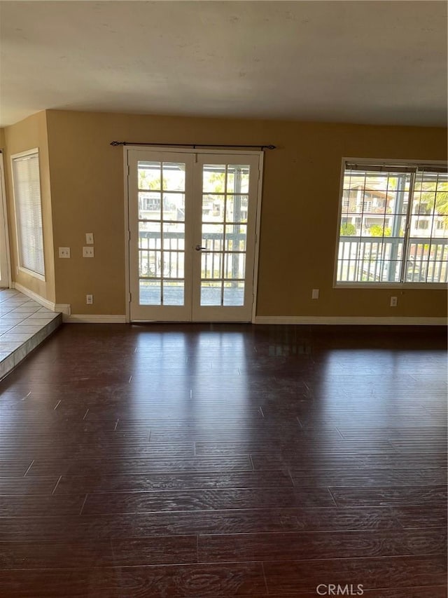 empty room with dark wood-type flooring and french doors