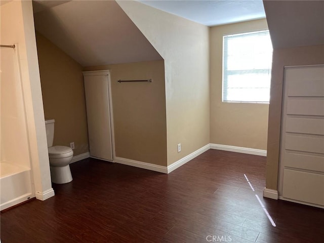 bathroom with hardwood / wood-style flooring, toilet, and vaulted ceiling