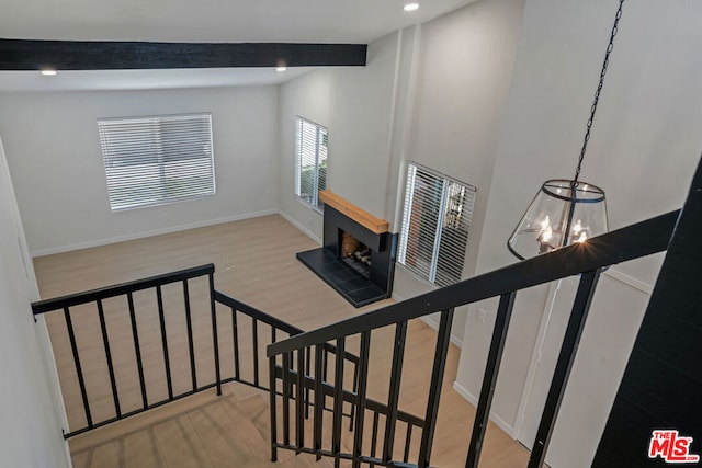 stairway featuring hardwood / wood-style flooring, vaulted ceiling with beams, and a notable chandelier