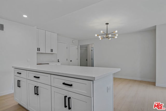 kitchen featuring white cabinetry, a kitchen island, pendant lighting, and light wood-type flooring