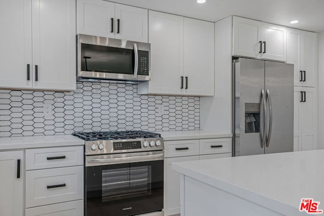 kitchen with stainless steel appliances, white cabinetry, and decorative backsplash