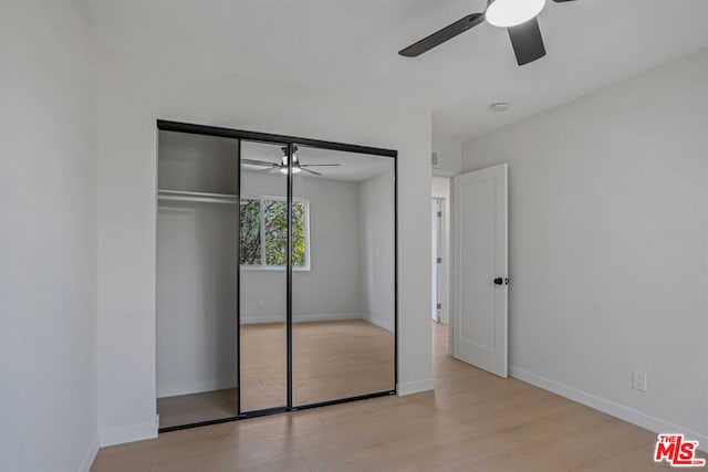 unfurnished bedroom with light hardwood / wood-style floors, a closet, and ceiling fan