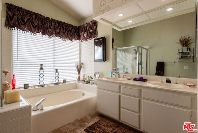 bathroom featuring vanity and independent shower and bath