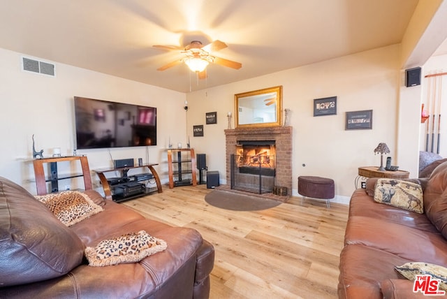 living room featuring hardwood / wood-style flooring, a fireplace, and ceiling fan