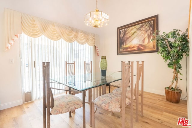 dining room with wood-type flooring and a notable chandelier