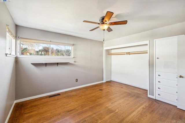 unfurnished bedroom featuring hardwood / wood-style floors, ceiling fan, and a closet