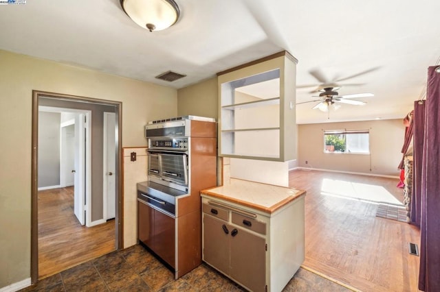 kitchen featuring dark hardwood / wood-style floors, stainless steel oven, and ceiling fan