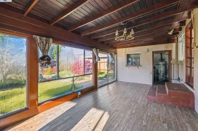 unfurnished sunroom featuring beamed ceiling and wood ceiling