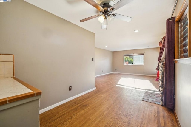 unfurnished living room with hardwood / wood-style flooring and ceiling fan