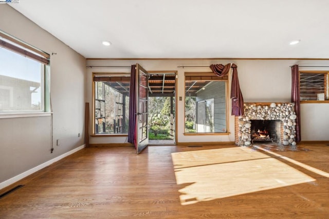 unfurnished living room featuring ornamental molding, hardwood / wood-style floors, and a fireplace