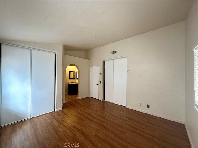 unfurnished bedroom with dark wood-type flooring