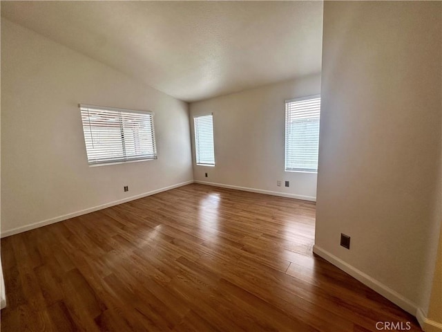 unfurnished room with lofted ceiling, dark hardwood / wood-style flooring, and a wealth of natural light