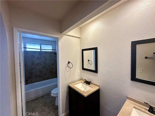 full bathroom featuring vanity, tiled shower / bath combo, tile patterned floors, and toilet