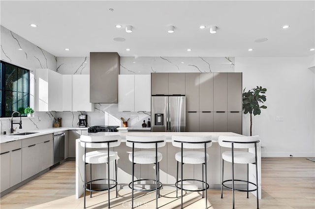 kitchen featuring stainless steel appliances, a center island, sink, and a breakfast bar