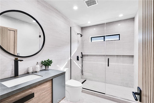 bathroom with a shower with door, vanity, and toilet