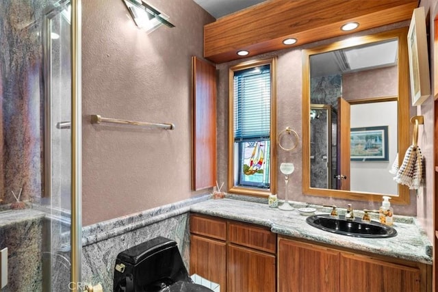 bathroom with vanity and a shower with door