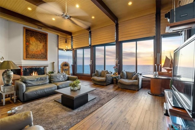 sunroom featuring ceiling fan, wooden ceiling, and beam ceiling