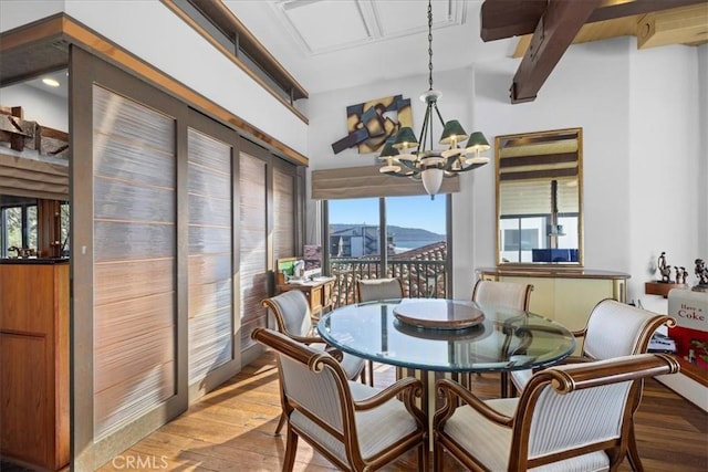 dining space featuring hardwood / wood-style flooring, a mountain view, and a chandelier