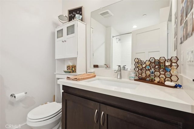 bathroom featuring vanity, toilet, and walk in shower