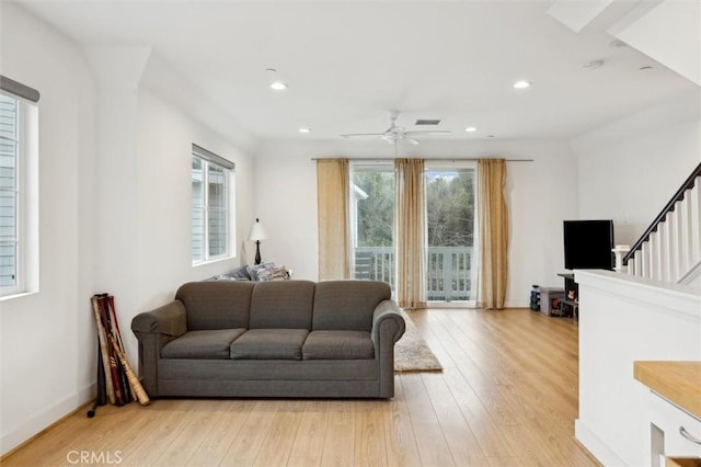 living room featuring light hardwood / wood-style floors and ceiling fan