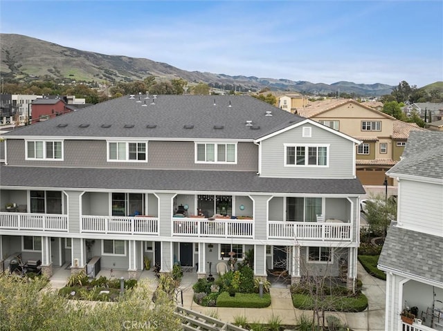 back of property with a balcony and a mountain view