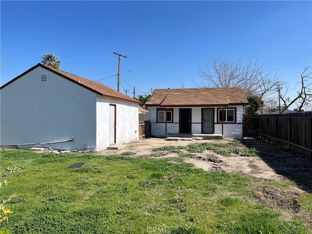 rear view of property featuring a lawn