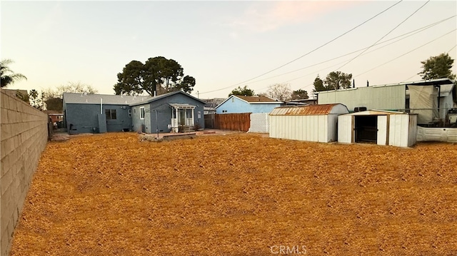 yard at dusk featuring a storage unit